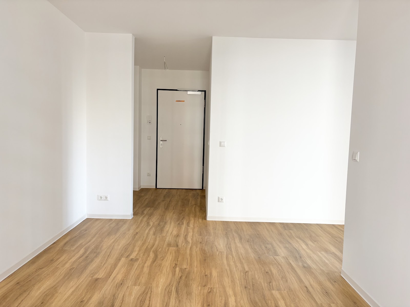 Offener Blick auf die Eingangstür des Apartments mit Bereich für Garderobe.